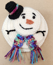 Crocheted melted snowman with a lack hat and a variegated scarf