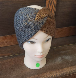 Messy bun ear warmer in colors moving from grey to brown   displayed on a manikin with a wooden background
