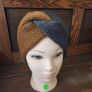 Messy bun ear warmer in colors moving from grey to brown displayed on a manikin with a wooden background