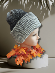 beanie hat in colors going from grey to black displayed on a manikin with autumn leaves
