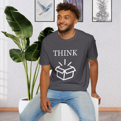 a man sitting on a stool in front of a plant wearing a charcoal grey T-Shirt that says the Word Think in white ink above a picture of an open box which is also white.
