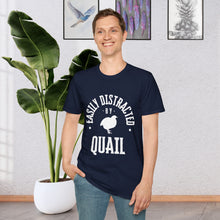 A man standing in front of a plant wearing a Navy Blue T-shirt that says Easily distracted by Quail in white lettering. The shirt has a silhouette of a quail in the center.