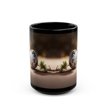 A black mug sitting on the counter with Quail eggs and a pine branch sitting on a sandy floor wrapped around the outside.