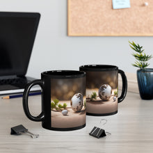 Two black mugs sitting on the counter with Quail eggs and a pine branch sitting on a sandy floor wrapped around the outside.